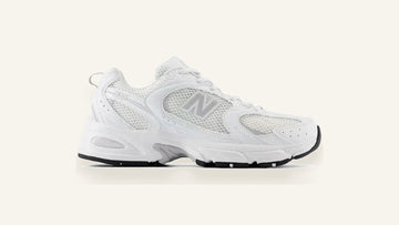 New Balance 530 branco sobre fundo osso, par limpo e pronto para uso