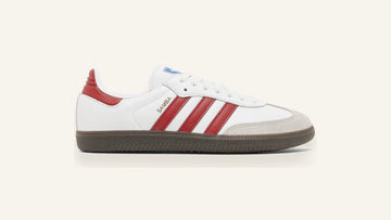 adidas Samba OG branco com listras vermelhas e sola de goma sobre fundo osso